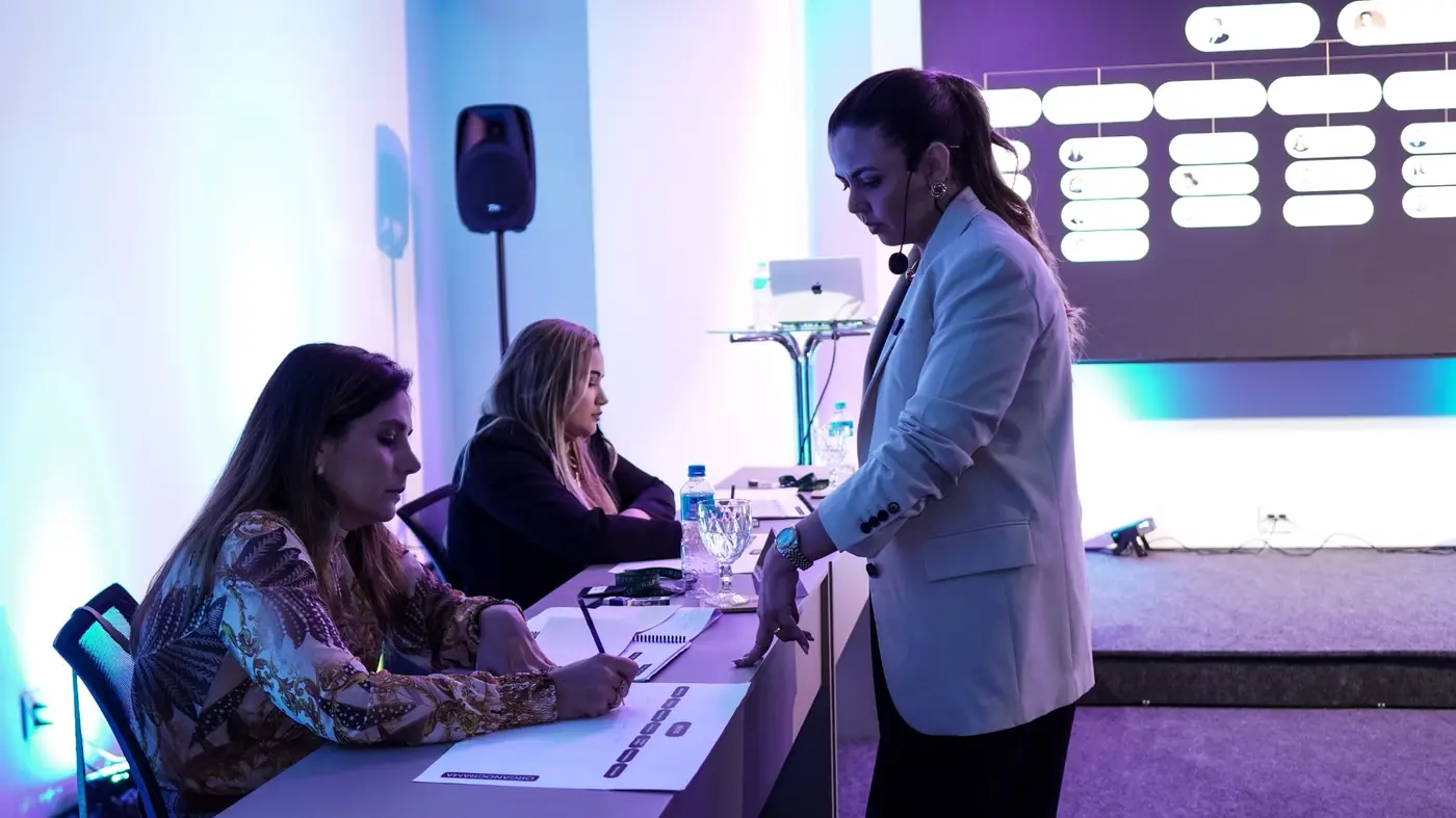 Mentora conduzindo dinâmica no palco